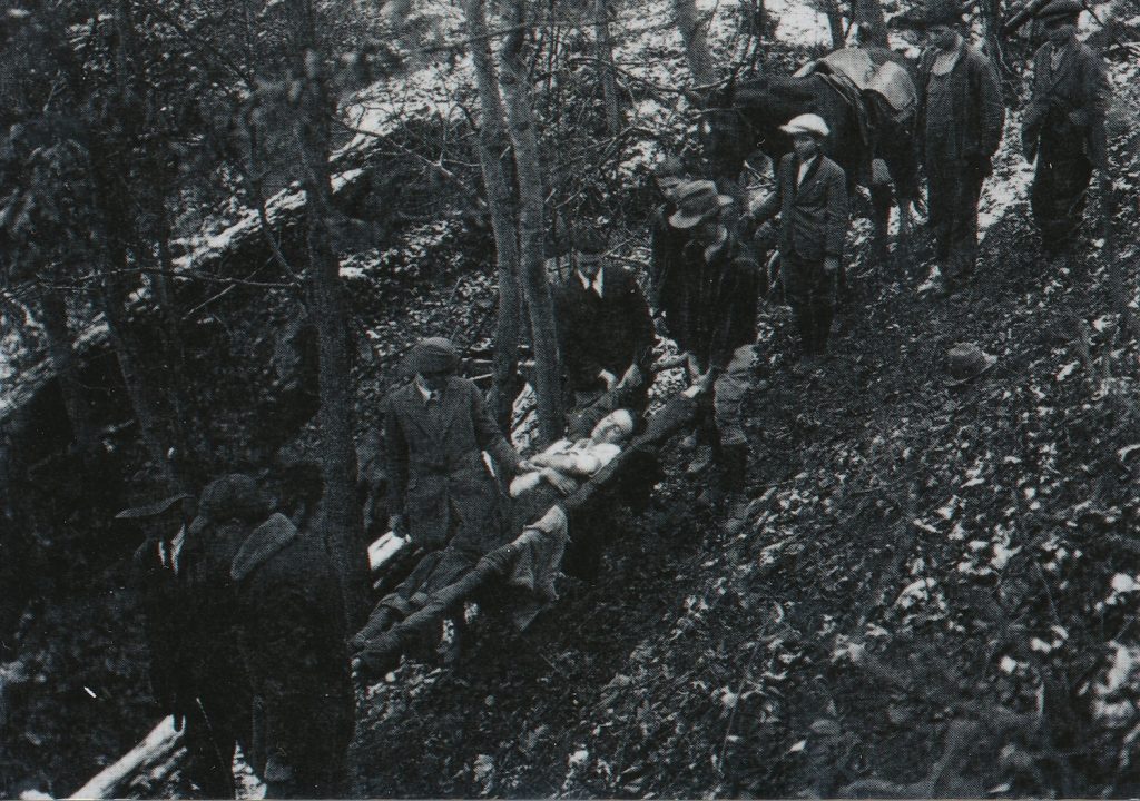 Local men carrying a person down the mountain.